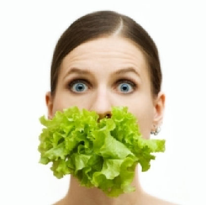 Woman with lettuce blocking her mouth